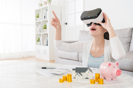 happy elegant mother planning using family deposit buying new house and watching 3D building video information to choosing suitable apartment through virtual reality device.の写真素材