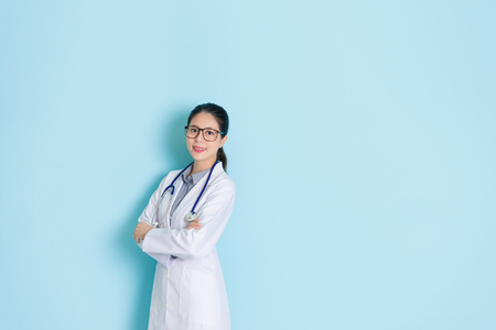 sweet pretty rights woman doctor medical care patient healthy and smiling face to camera standing in blue wall background with empty area.の写真素材