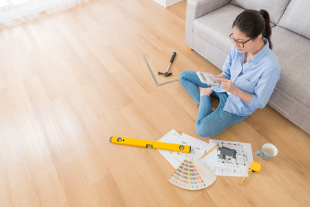 high angle view photo of elegant beauty girl engineer sitting on floor using calculator counting house remodeling price.の写真素材