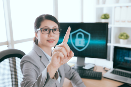 select focus photo. smiling beautiful woman pointing pressing virtual screen interface doing information security working.の写真素材