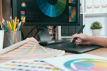 selective focus photo of graphic designer using digital pad pen work.