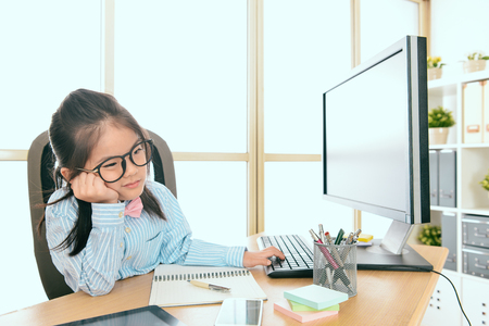 lovely beauty little girl children dress up as business woman sitting in office feeling boring.の写真素材