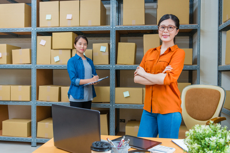 professional confidence online shopping office workers looking at camera and working on warehouse processing order to shipping for client.の写真素材