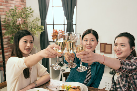 asia women hands holding glasses and toasting up, happy festive moment, successful business celebration concept.の写真素材