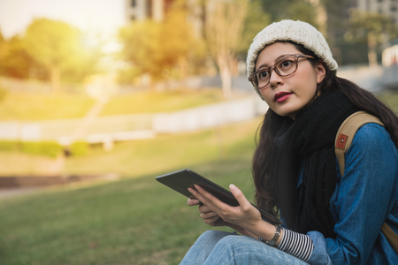 beautiful girl using the e-learning ebook with digital tablet and look away in winter park on a sunny day.の写真素材