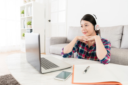 elegant smiling female student watching online e-learning system education video to study.の写真素材