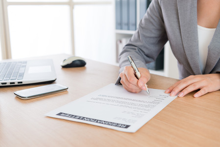 closeup of business woman decided retired from company and writing personal resignation letter explaining plan in future to application leaving.の写真素材