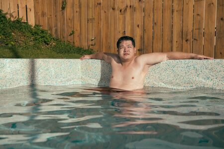 handsome fat man going travel during summer vacation holiday and sitting in country villa swimming...