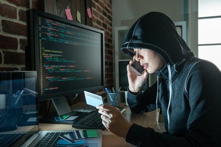 female hacker doing phone fraud and robbery. demanding victim money thru stolen credit cards. speaking and blackmailing poor victims.の写真素材
