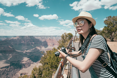 young girl tourist wearing straw hat on summer vacation. elegant asian woman travel wild sunny day.