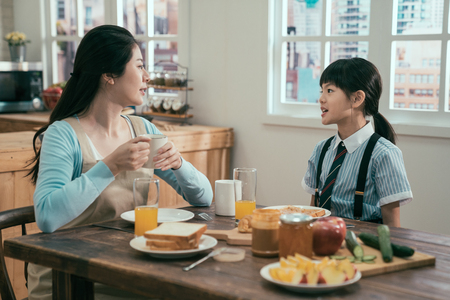 young asian korean mother and daughter having breakfast together in morning at home.の写真素材