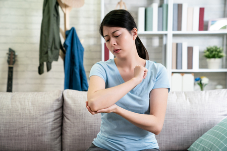 unhappy young asian woman with elbow pain.の写真素材