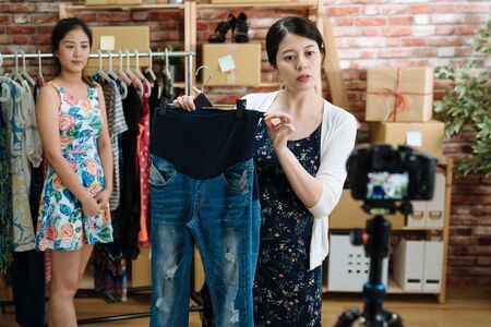 young pregnant woman showing maternity pants jeans to camera selling online small business shop on...
