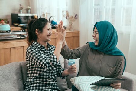vintage style picture of group asian young female people happy giving high five celebrating successful shopping on online summer sale.の写真素材