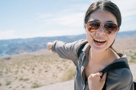 excited vlogger traveling to arid region pointing and introducing distinctive landscape to fans....