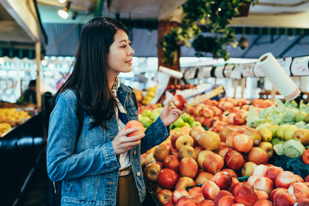 portrait beautiful lady holding apples is looking at the fresh fruits with smile.の写真素材
