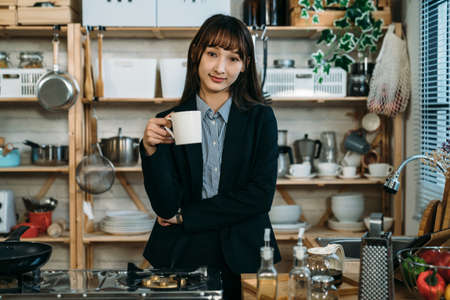 Pretty business woman having breakfast and drinking juice in the kitchen. Welcome a wonderful day for the new challenge work.の写真素材