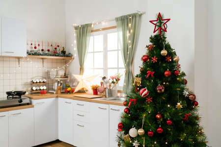 beautiful Christmas and new year decorated kitchen with xmas tree and LED light decors on the windowの写真素材