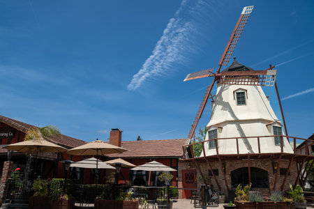 California, USA - May 20, 2018: giant windmill against sunny blue sky outside a restaurant with outdoor seating. famous tourist attraction in solvang Danish villageのeditorial素材