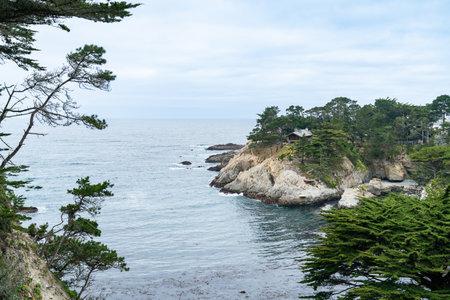 California, USA - May 19, 2018: beautiful seascape and skyline of big sur along California highway one with cypress trees and houses at sea shore on cloudy dayのeditorial素材