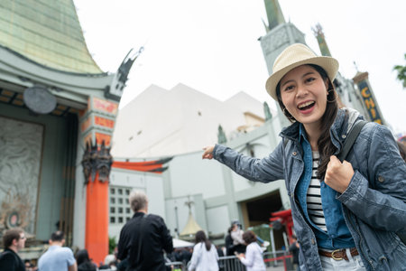 Asian woman travel backpacker vivacious tourism in los angeles standing on hollywood walk of fame with beautiful beaming smile on busy street.の写真素材