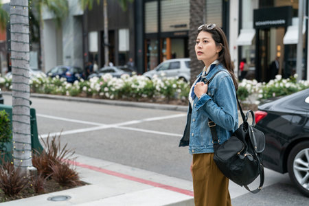 female commuter is looking at surroundings along the street on her way to school.の写真素材