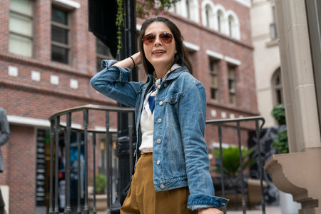 modern millennial lady is looking into distance from a high place, background red brick buildingの写真素材