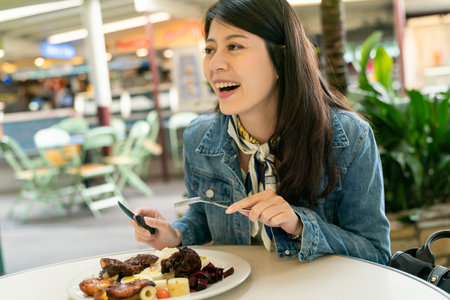 Asian Japanese woman is happy to chat with friends while eating grilled steak meal outdoors. Women enjoy having food with laughing.の写真素材