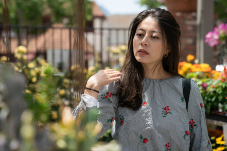 selective focus with cloesup portrait of attractive asian chinese woman shopping for fresh garden plants at a flower market in downtown solvang California usaの写真素材