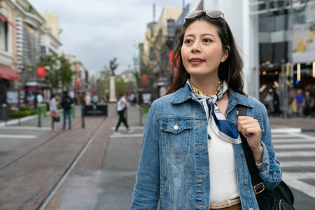 elegant woman crossing road, she looks relax because today is her holiday, she is going shoppingの写真素材