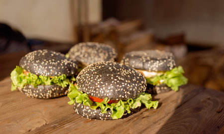 Yummy homemade burgers in hand. Sesame bun, green salad, pork cutletの写真素材