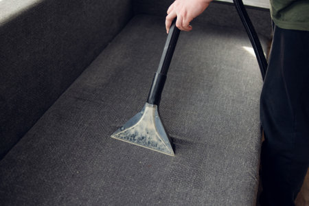 Washing vacuum cleaner cleans the sofa from dirt