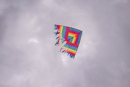 Rainbow colorful kite flying in the skyの写真素材
