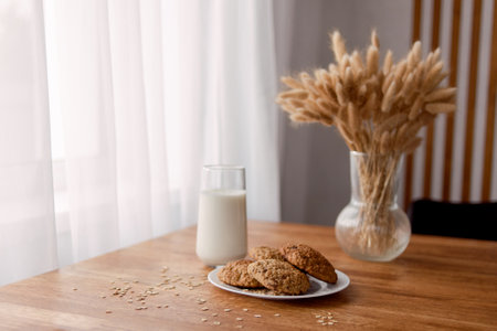 Homemade oatmeal cookies with oats, eggs and flour free on brown dark wooden table, side view.の写真素材