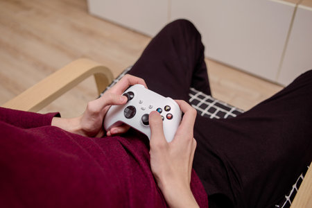 A man playing a console, holding a joystick in his hands