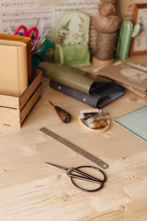 Creative Corner. Details on a wooden work table, scissors, thread, fabrics.の写真素材