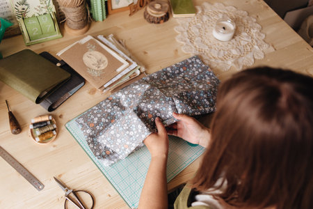 A creative person makes a scrapbook or notebook in their office. Handmade, exclusive