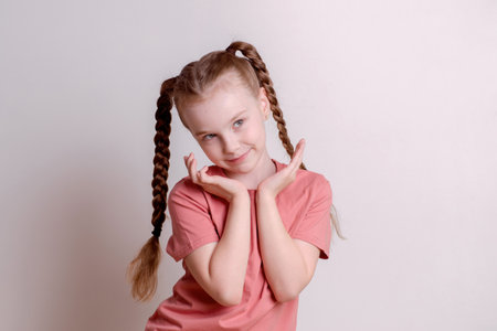 Pretty girl against a white wall, posing and smilingの写真素材