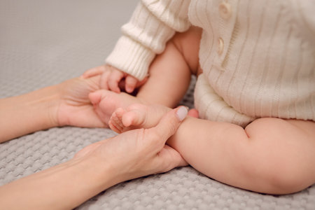 Happy Motherhood. Moms hands holding the babys little legsの写真素材