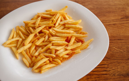 Crispy fries. Cooking fries. A tasty snack. Unhealthy food.