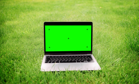 Notebook on the green grass of the campus lawn. Green screen laptopの写真素材