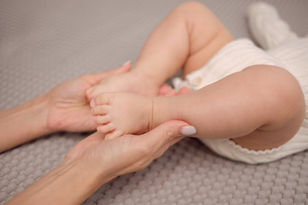 Happy Motherhood. Moms hands holding the babys little legs
