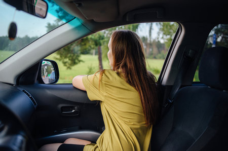 Portrait of a woman sitting in a car admiring nature. Freedom concept of traveling.の写真素材
