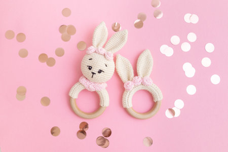 Cute wooden baby toys on a pink background. Eco accessories and teethers for newborns. flat plan,...