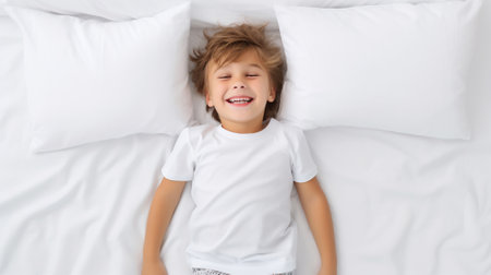 a child of 3-4 years old lying on a white blanket and pillows, happiness and funの素材