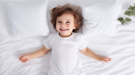 a child of 3-4 years old lying on a white blanket and pillows, happiness and funの素材