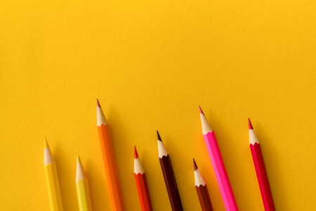 Lots of colored pencils on the yellow background of the desk. Back to school. Children's Creativity and Education. High quality photoの写真素材
