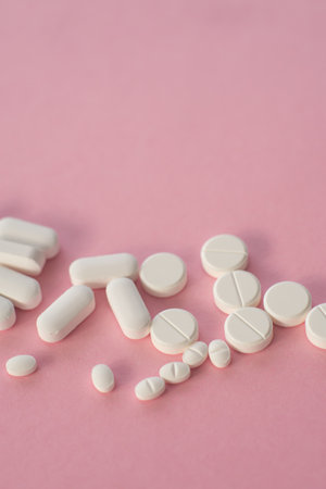 medicine tablets antibiotic pills on a pink background, cold and disease treatment