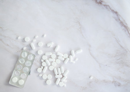 white tablets antibiotics and medicines on a light background, close-up