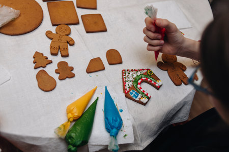 kids making gingerbread men and gingerbread house during the holidaysの写真素材